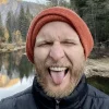 Geoff Graham in orange beanie and tongue sticking out.