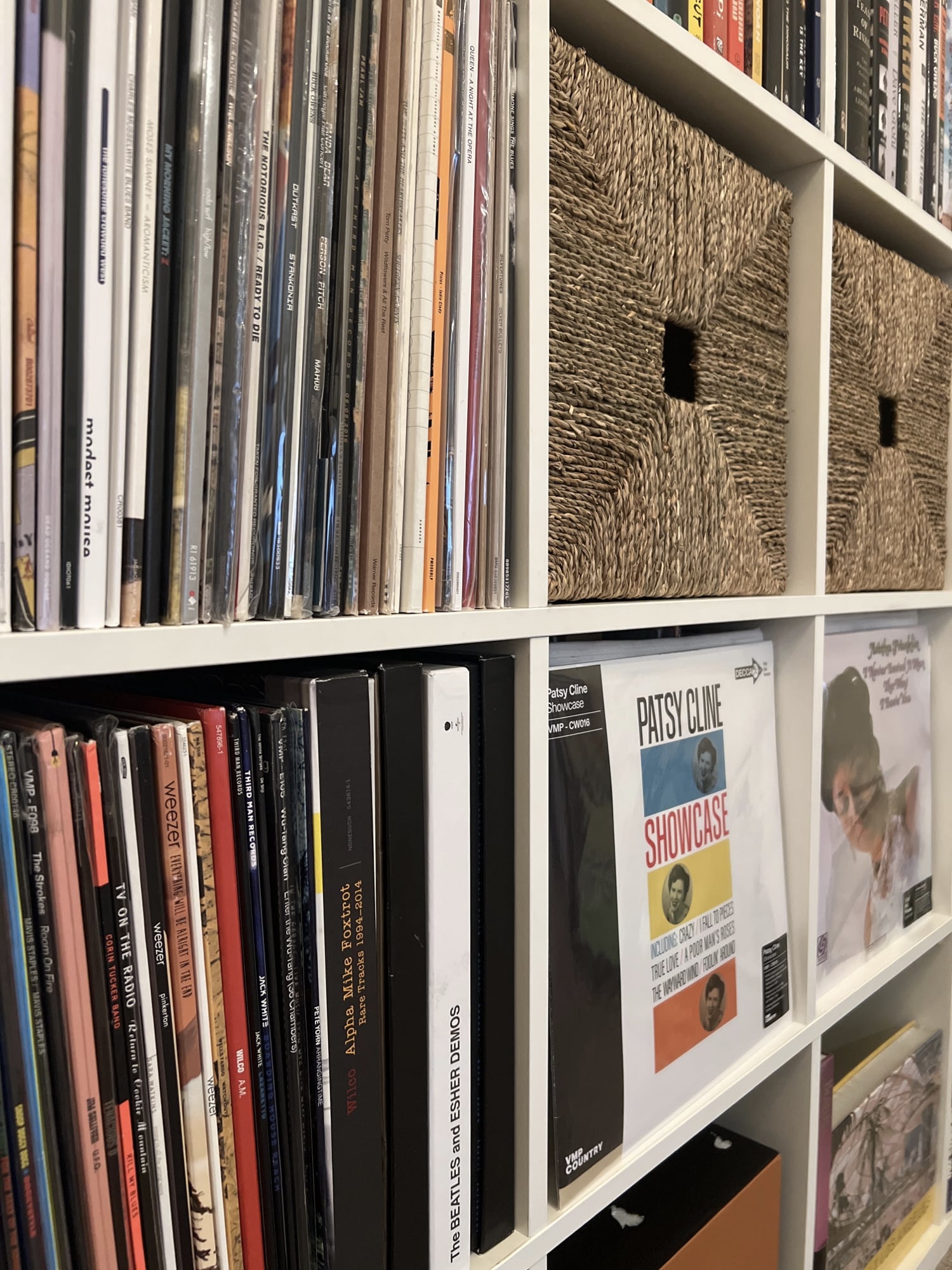 An Ikea media center with square cubes holding records ib alphabetical order.