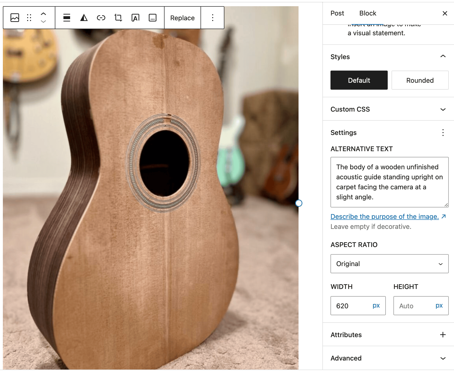 An image added to the WordPress block editor of an unfinished brown wooden guitar standing upright at an angle. The block's settings are open in the editor's right panel.